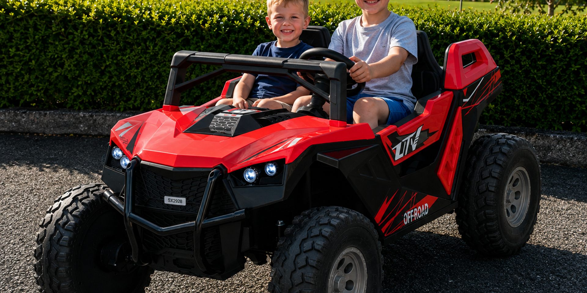 Children in a red electric ride-on buggy