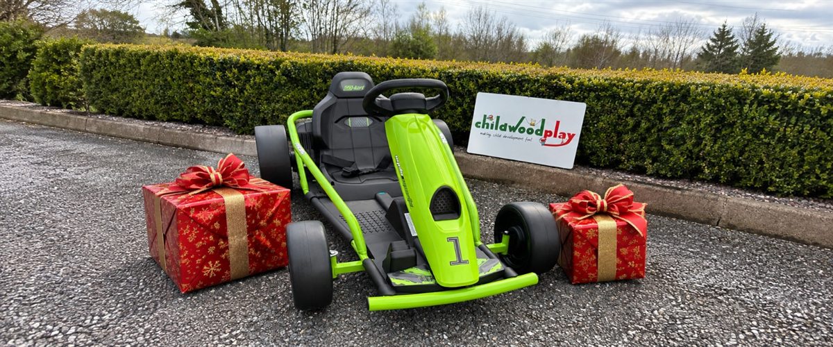 Green ride-on go-kart beside wrapped Christmas presents